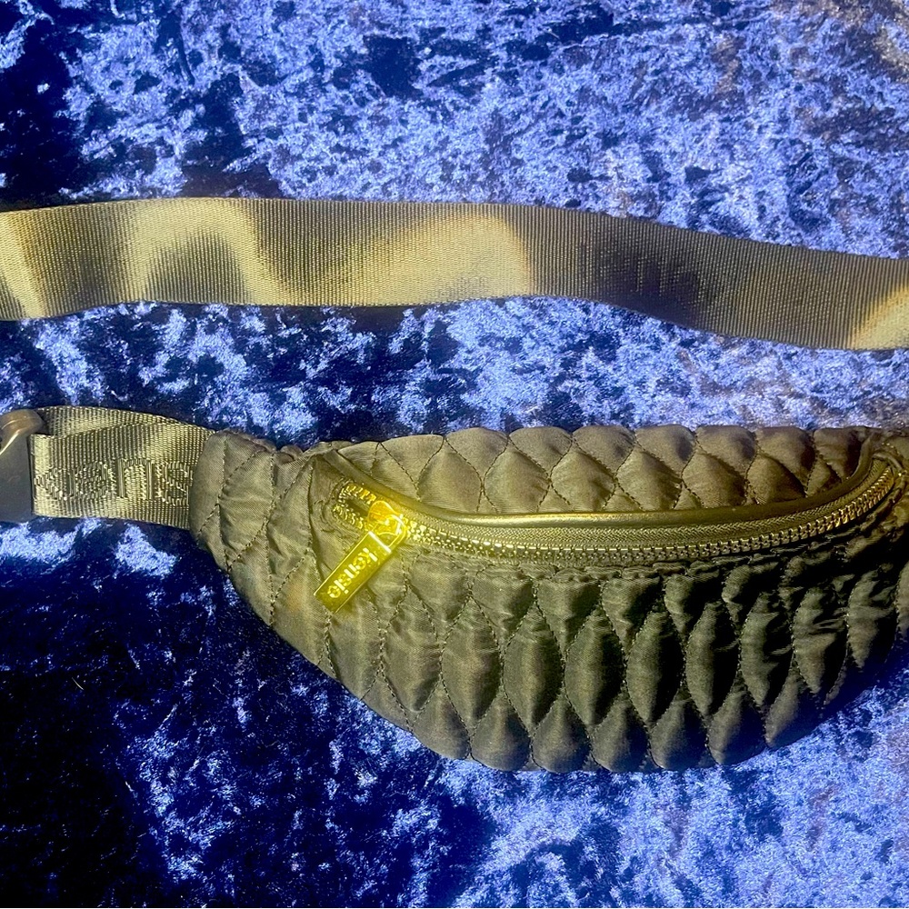 Black Kenzie zip up fanny pack with gold zippers and accents. Adjustable waist